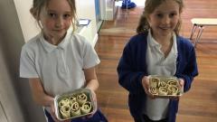 Olivia and Annie showing what they made at cooking club
